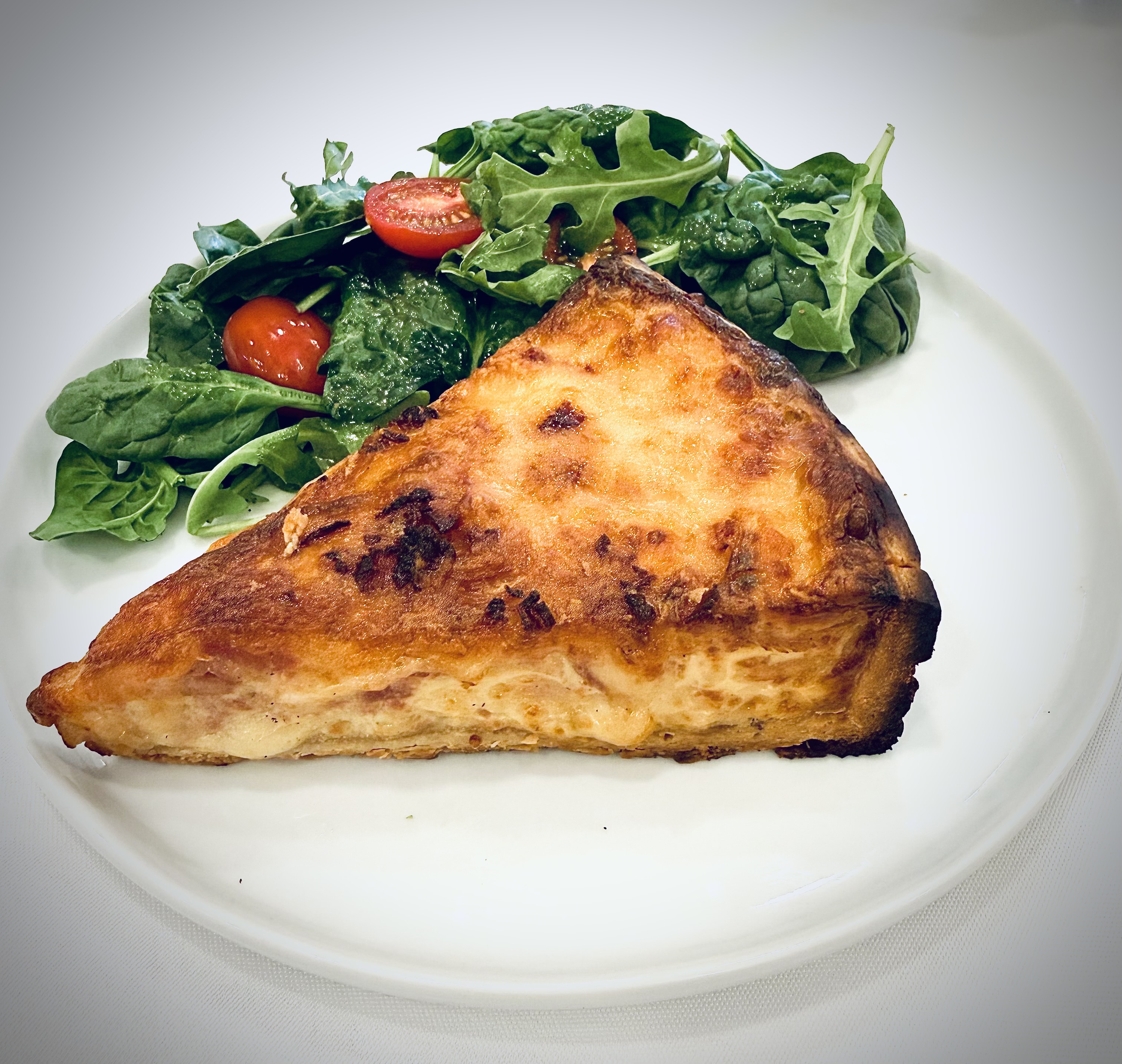 Signature quiche served with a simple garden salad